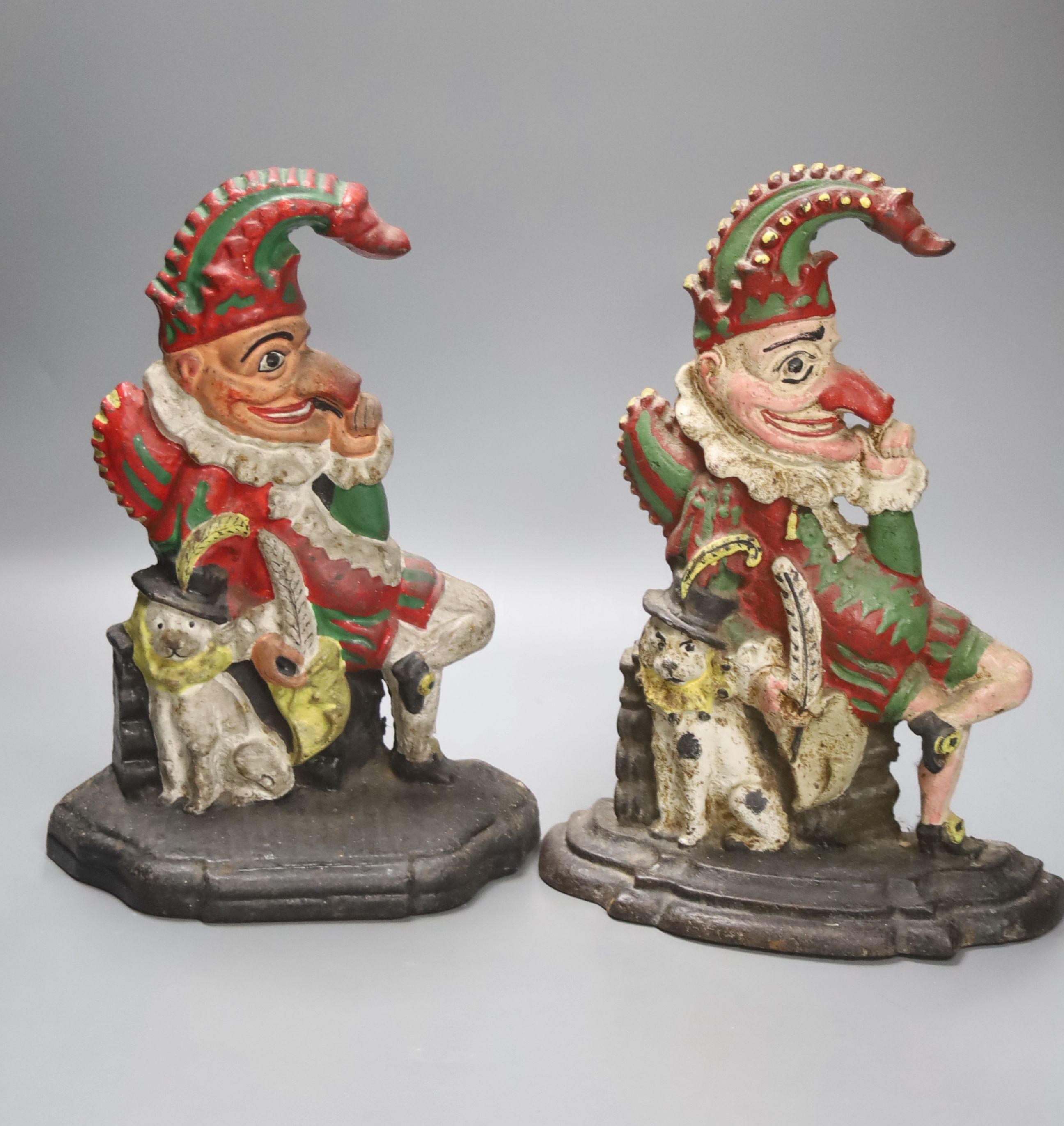 A pair of Victorian cast iron Punch and Judy door stops (later painted), one other and a pair of painted figural cast metal candlesticks, tallest 33cm